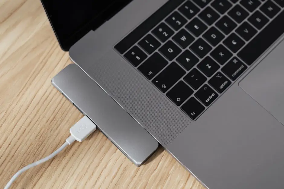لابتوب مع docking station USB-C وكيبل أبيض على مكتب خشبي - قرار سريع للشراء