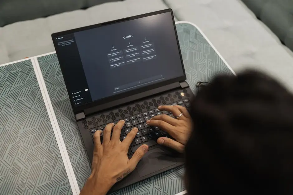 إطلاق Microsoft Copilot الجديد - يدان تكتبان على حاسوب يعرض واجهة الذكاء الاصطناعي