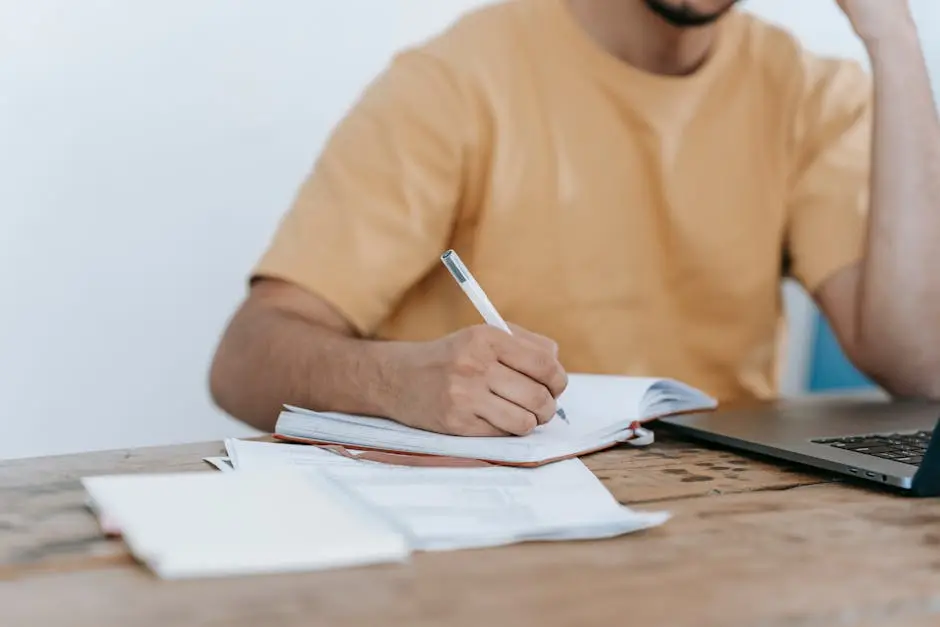 استخدام Notion بالعربي: شخص يدون ملاحظات بجانب الحاسوب