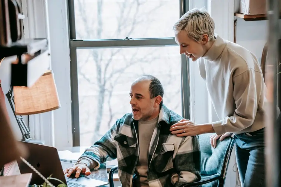 شخصان يستخدمان لابتوب معًا لتجربة برنامج AnyDesk للتحكم عن بعد