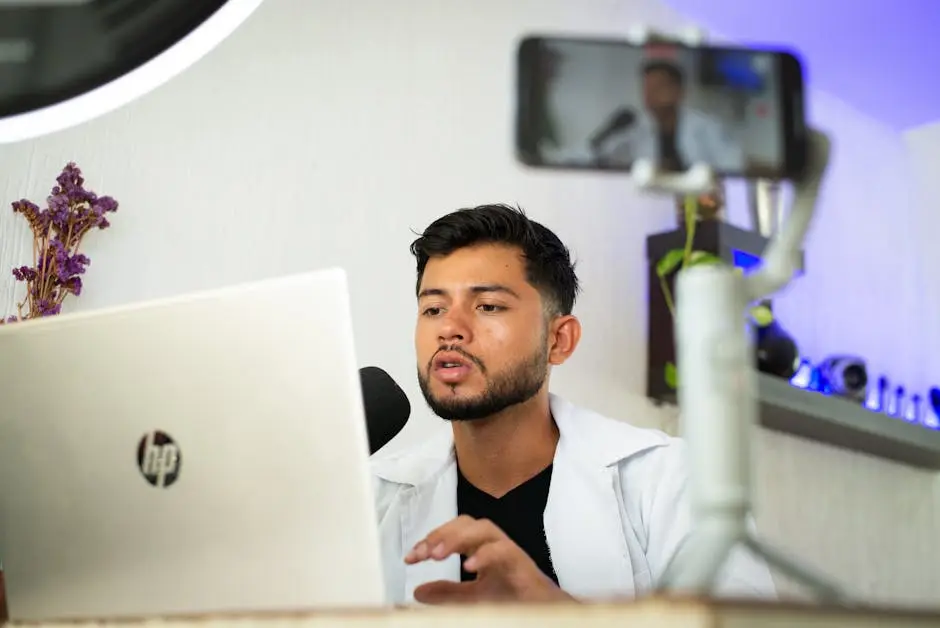 صانع محتوى يبث فيديو من لابتوبه ويستخدم هاتفًا لمراجعة أفضل برنامج مونتاج 2026