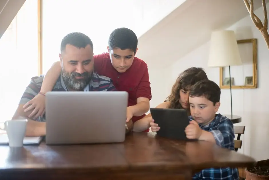أب وأطفاله مع الأجهزة الإلكترونية في المنزل - حلول لعائلة كبيرة