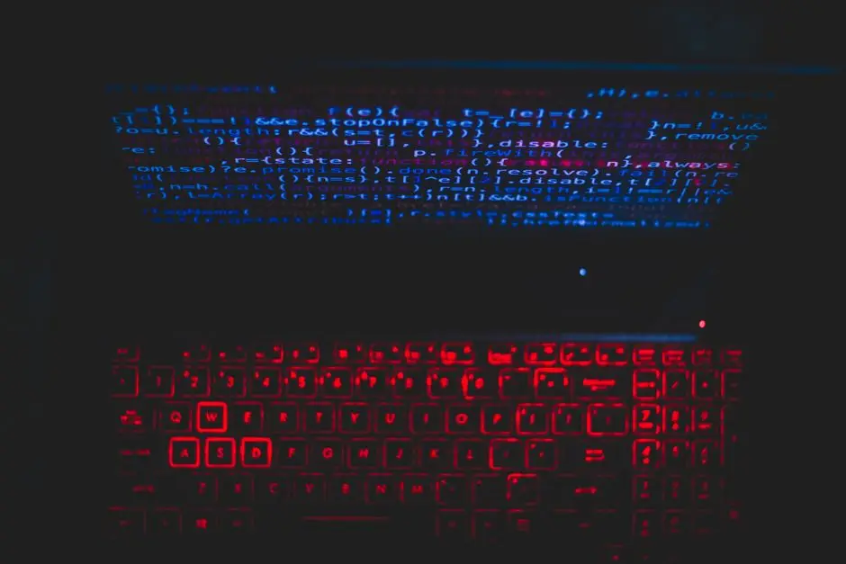 لابتوب داكن بلوحة مفاتيح حمراء متوهجة يرمز إلى مخاطر اختراق الذكاء الاصطناعي على الشركات العربية