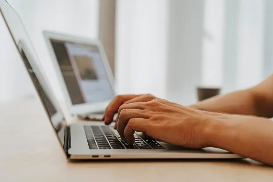 يد تكتب على لابتوب لاستخدام برنامج تحكم عن بعد مثل AnyDesk للدعم الفني