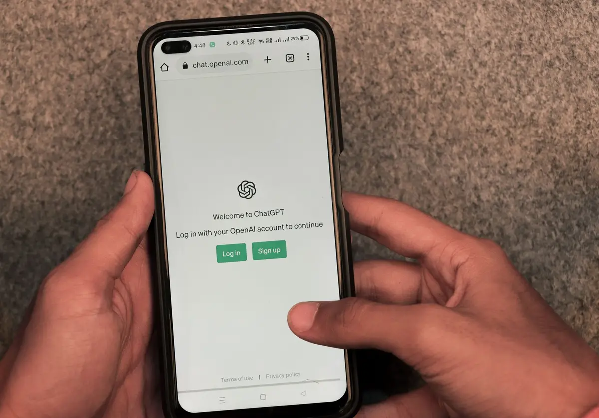 تطبيق ChatGPT على هاتف مع صفحة chat.openai.com الرسمية