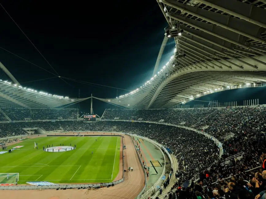 ملعب كرة قدم مضاء ليلاً بحضور جماهيري كبير