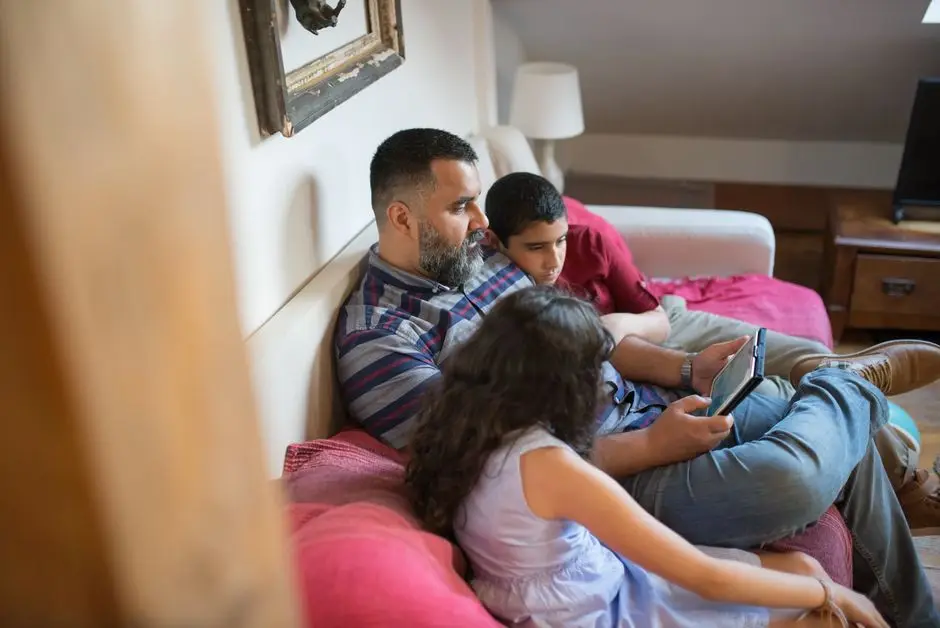 أب عربي يقضي وقتًا مع أطفاله حول جهاز لوحي ضمن إرشادات استخدام آمن للذكاء الاصطناعي
