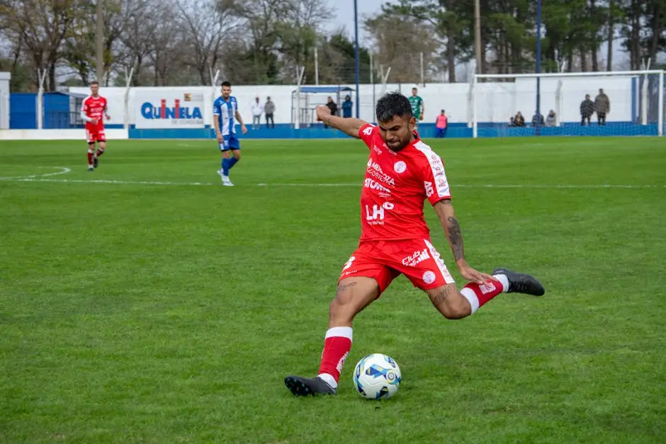 لاعب أرسنال بالقميص الأحمر يضرب الكرة في مباراة كرة قدم